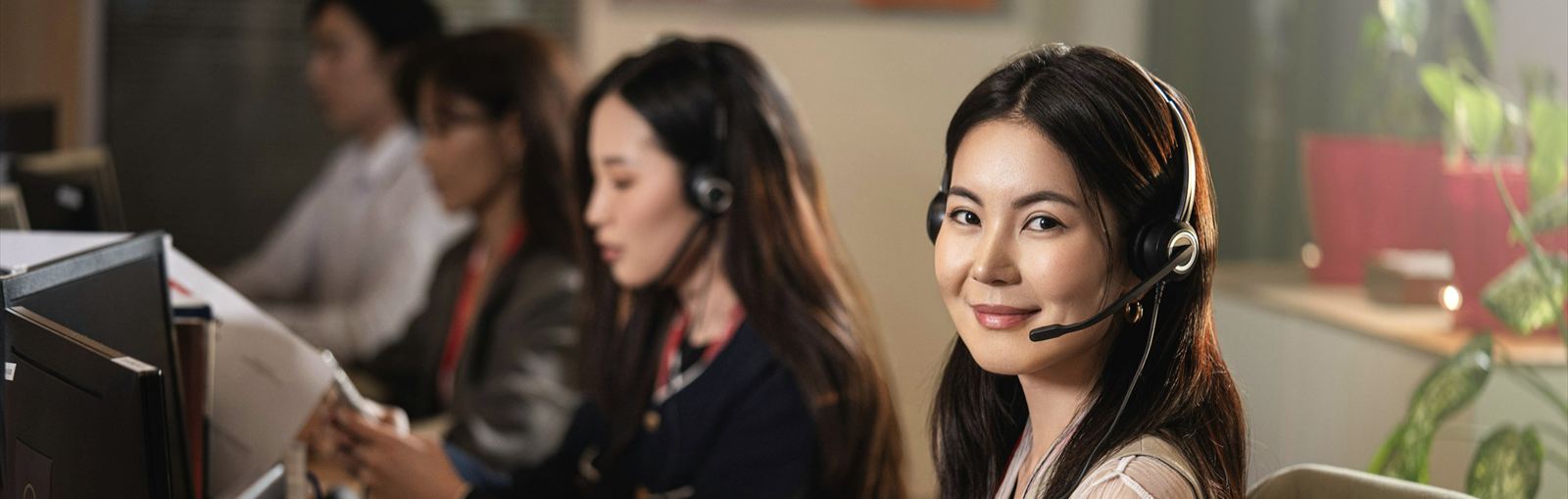 Équipe en open space équipée de casques-micros professionnels pour la téléphonie IP